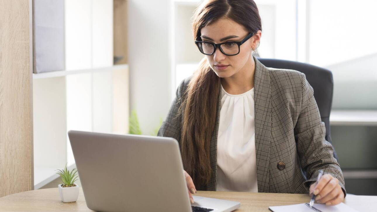 front view businesswoman working laptop office scaled 1