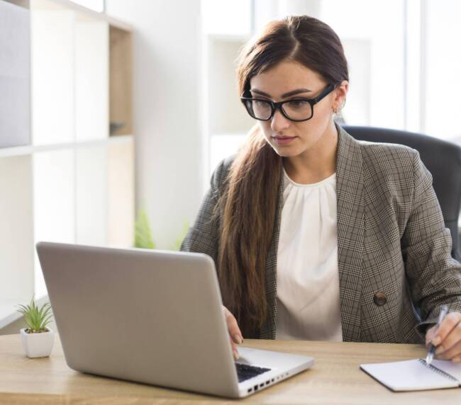 front view businesswoman working laptop office scaled 1
